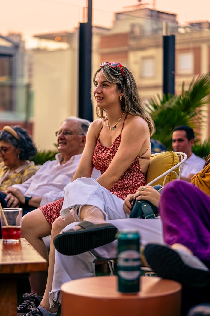 Casual group enjoying a relaxed evening on a rooftop patio at sunset.
