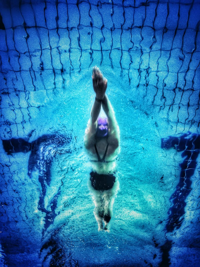 Mastering the First Impression: Your intriguing post title goes here Captivating underwater shot of a swimmer in a pool with clear blue water.