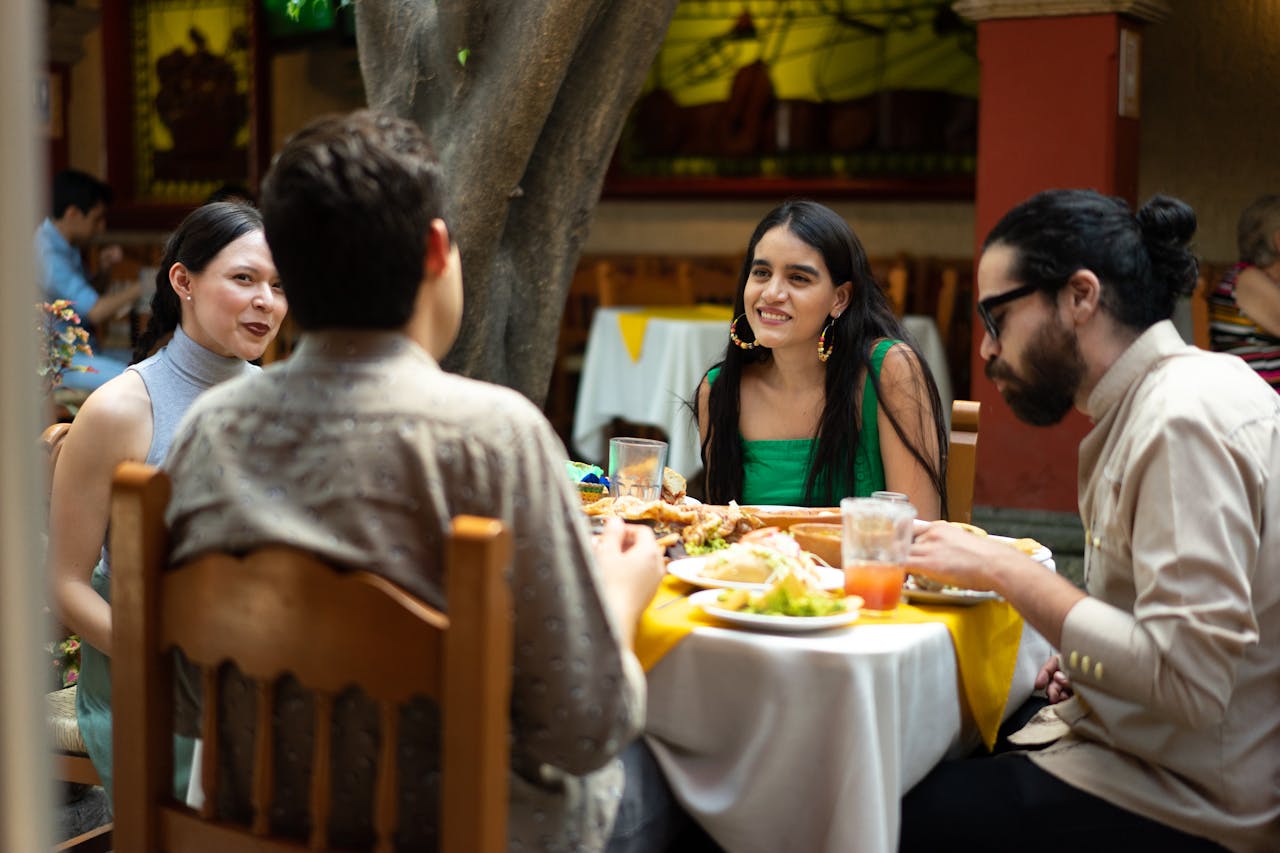 A group of friends enjoying Mexican cuisine outdoors at a vibrant restaurant.